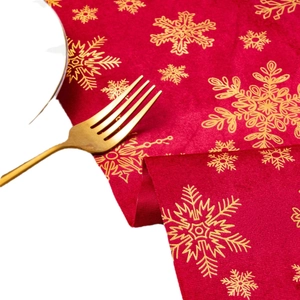 Red velvet Christmas table runner with golden snowflake prints and festive texture