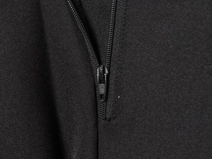 Gros plan sur la fermeture éclair en métal noir sur le tissu texturé du pantalon de loisir