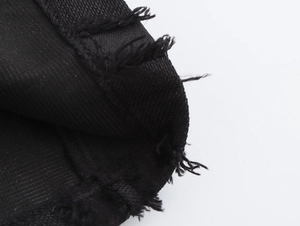 Gros plan détaillé montrant l'ourlet à bords effilochés et la texture denim de la robe sans manches
