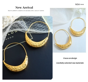 Detail of vintage gold textured croissant earrings with a hammered metal surface design