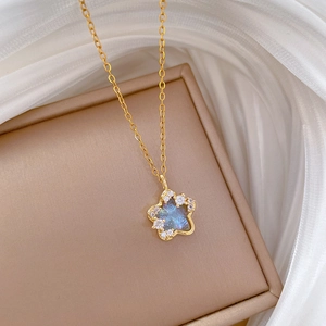 Elegant gold titanium steel star necklace with blue center and crystal pavé details