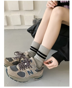 Close-up of grey combed cotton crew socks with double black stripes on model