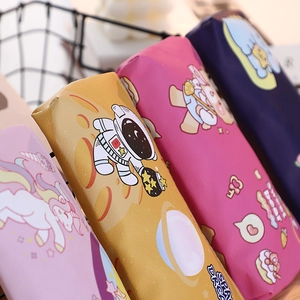 Close-up of four colorful cartoon pencil cases with unicorn and astronaut motifs in a basket