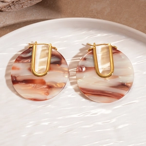 Detailed macro view of 18k gold-plated U-shaped earrings with brown marble resin texture