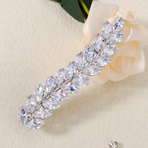 Close-up of silver leaf-shaped hair clip with marquise zirconia on white flowers
