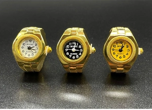 Detailed close-up of three gold quartz ring watches with black, white, and yellow dials