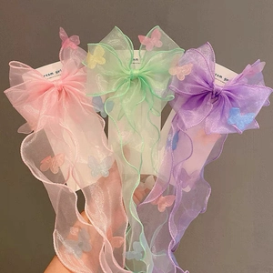 Detailed close-up of pink, mint, and purple organza bow clips with long ribbons