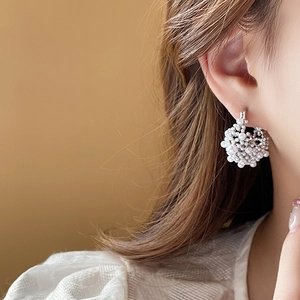 Close-up of cluster faux pearl earrings with gold plating on female model