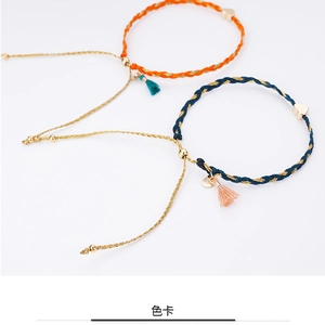 Detail of hand-woven friendship bracelets featuring golden heart charms and colorful tassels