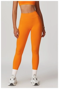 Detail of high-waist ribbed waistband on orange seamless yoga pants with high elasticity