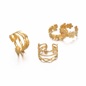 Close-up of golden stainless steel open rings with floral patterns and pearl details
