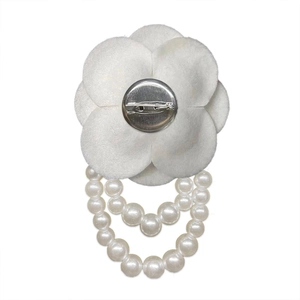 Vintage camellia flower brooch with white petals and hanging pearl chains in 45-degree view