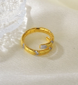 Macro shot of gold snake ring with pavé stones on a silk textured surface