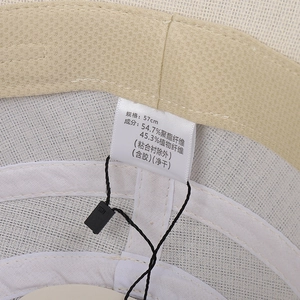 Close-up of woven sun hat interior with 57cm size label and washing instructions tag
