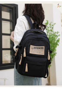 Close-up of the multi-pocket large capacity black nylon backpack with a leather logo patch