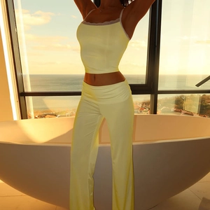 Dettaglio del set giallo con crop top in pizzo e pantaloni da yoga a campana chic
