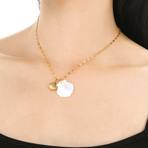 Close-up of shell pendants on a gold chain necklace worn to show actual size and texture