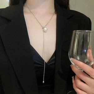 Minimalist Y-shaped necklace with white pearl and silver bead on model in black suit