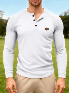 Detail of white waffle knit Henley shirt featuring a leather logo patch on the sleeve