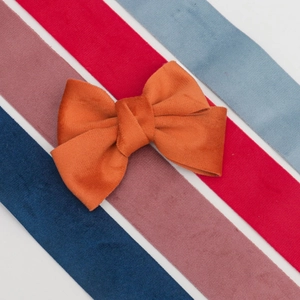 Détail d'un nœud en velours orange posé sur des rubans colorés aux tons variés