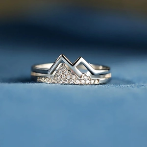 Detailed macro view of layered silver mountain rings with sparkling pavé zircons
