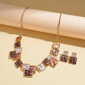Detail of bohemian necklace and earrings with irregular textured gold and bronze geometry