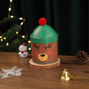 Christmas reindeer tin canister with green lid and red pom-pom for festive candy storage