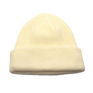 Close-up of beige thick knit beanie showing the premium ribbed texture and folded cuff