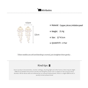 Detail view of long tassel pearl earrings with cubic zirconia in gold and white finish