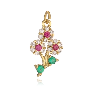 Golden floral pendant with red gems and green leaves shown on a white background