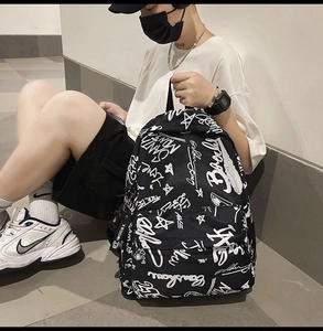 Detail of black and white graffiti canvas backpack with trendy street style letter prints
