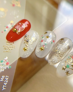 Macro shot of 3D gold snowflake and red polka dot Christmas themed nail art stickers