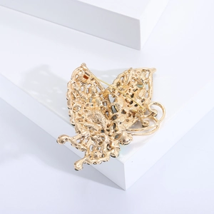 Detail showing the sturdy pin back and golden butterfly brooch structure on a white block