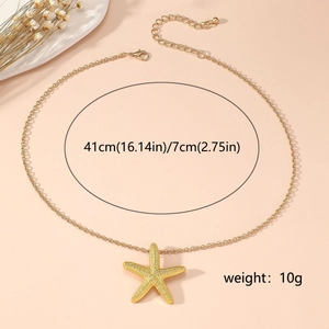 Close-up of gold starfish necklace with 41cm chain and 7cm extension on apricot background
