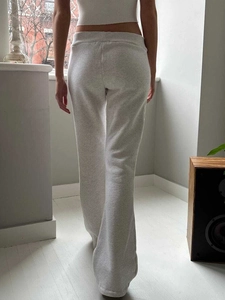 Rear view of light grey wide leg yoga pants with elastic waistband on a model