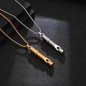 Polished gold and silver stainless steel whistle pendant necklaces on dark background