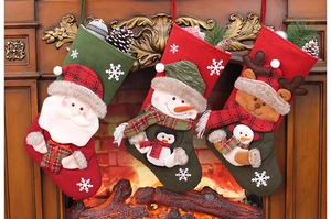 Hanging Christmas stockings with 3D Santa, Snowman, and Reindeer icons by a warm fireplace