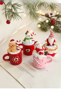 Macro shot of festive resin Christmas miniature figurines on decorative mugs with warm lights