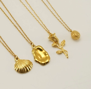 Detail of gold rose necklace and shell pendant with minimalist polished metal finish