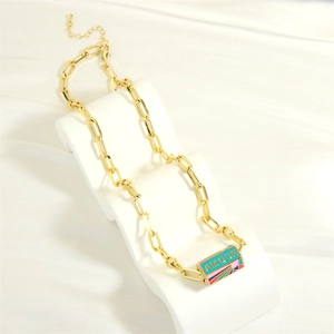 Detail of gold chain necklace with blue AMOUR enamel pendant on a wavy display stand