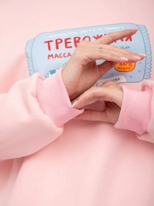 Nahaufnahme des rosa Sweatshirts mit russischem Textdruck und gerippten Bündchen