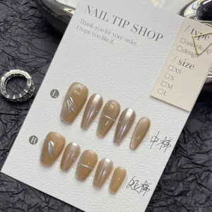 Detail view of champagne cat-eye press-on nails with silver relief on a white card