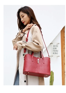 Red crocodile embossed tote bag styled with a beige trench coat for a chic outdoor look