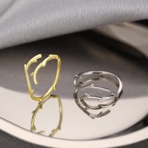 Minimalist branch twig open rings in gold and silver finish on a grey silk background