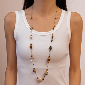 Vintage amber glass beaded necklace with butterfly and star charms on model