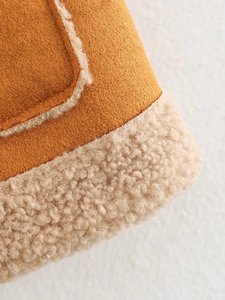 Detailed close-up of faux lamb wool lining and brown suede fabric texture on vest