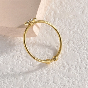 Detail of adjustable gold ring with crystal floral design and bead ends on stone
