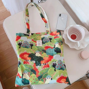 Détail d'un sac cabas en toile avec illustration de chat et forêt sur un bureau