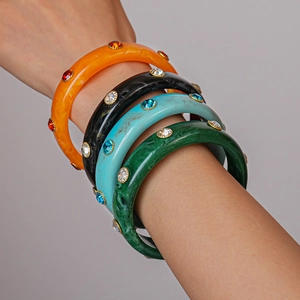 Macro shot of colorful acrylic resin bangles with marble texture and embedded rhinestones