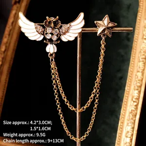 Detailed view of enamel owl brooch with gold star charm and double fringe chains